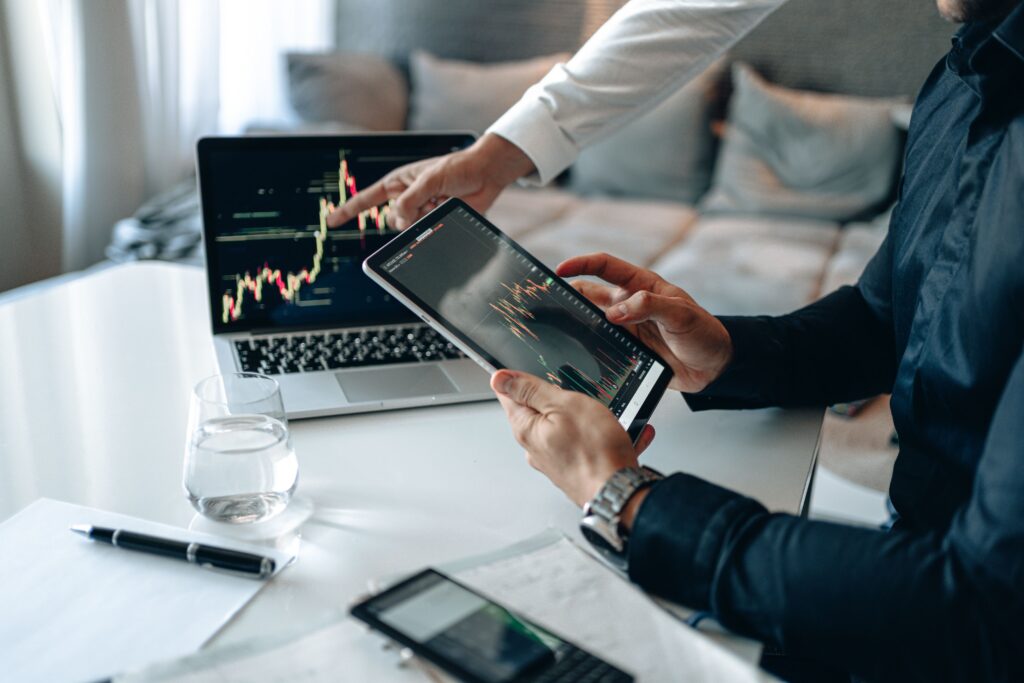 Marketing specialists analyzing digital campaign data and performance metrics on multiple devices.